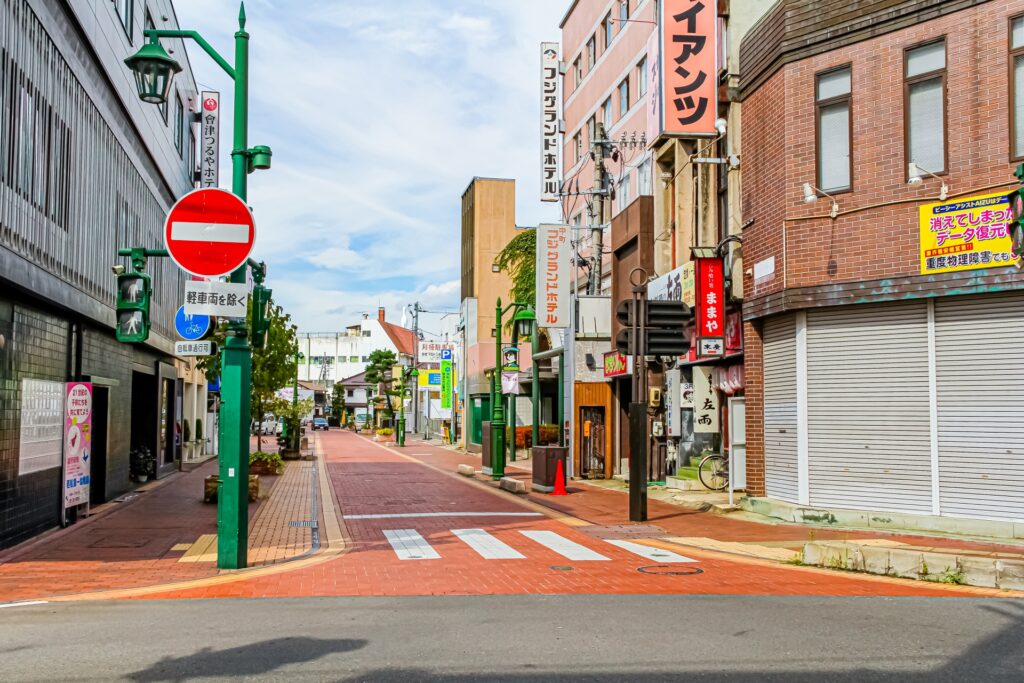 商店街入口に設置された車両進入禁止の標識。赤い丸に白い横線の標識の下には『軽車両を除く』と補助標識があり、自転車は通行可能であることを示している。歩行者と自転車は進入できるが自動車は進入禁止となる道路の例。ペーパードライバー講習や運転免許試験対策の標識学習に役立つ交通ルール解説。