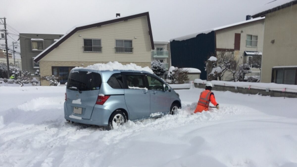 雪で埋まりそうな車