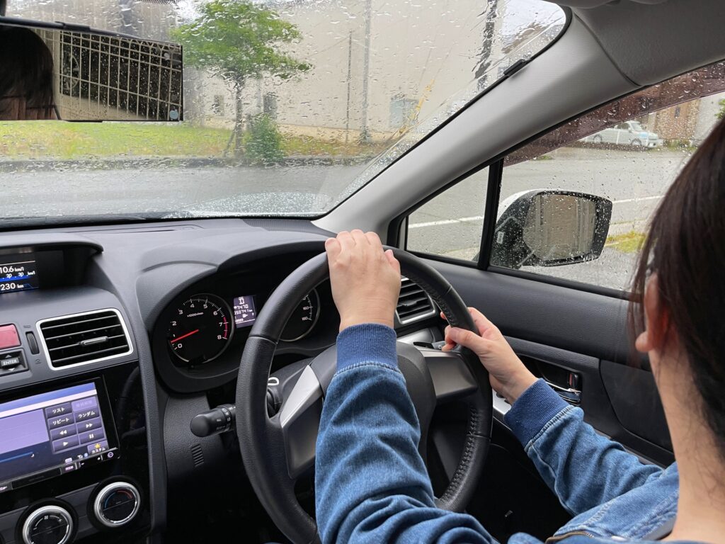 雨の日に運転する女性ドライバー